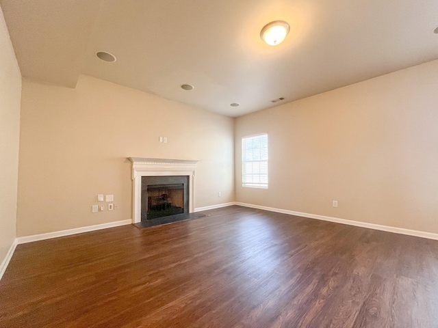 unfurnished living room with baseboards, dark wood-style floors, and a fireplace