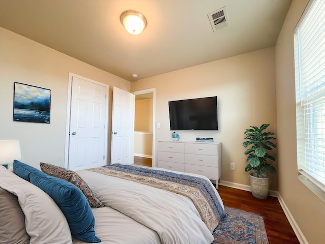 bedroom featuring wood finished floors, visible vents, and baseboards