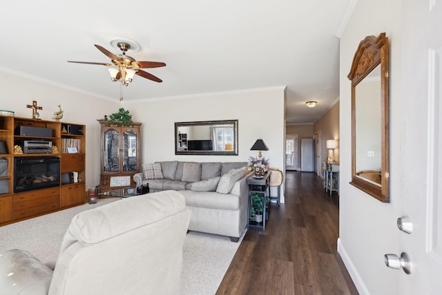 living area with crown molding, dark wood-style floors, baseboards, and ceiling fan