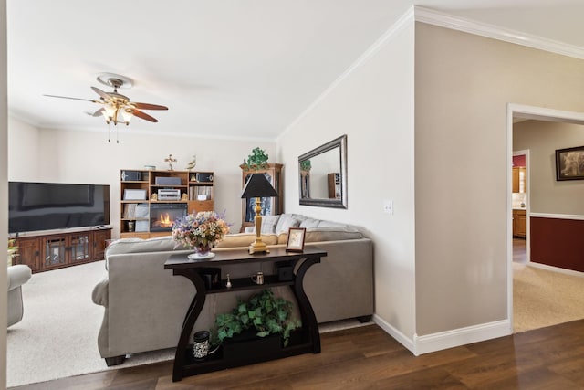 living room with crown molding, baseboards, and wood finished floors