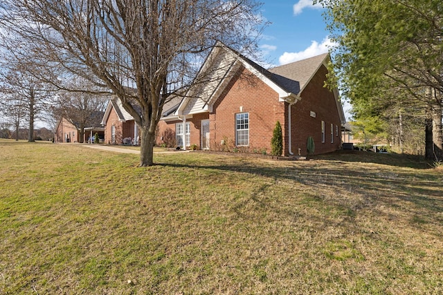 exterior space with brick siding and a lawn