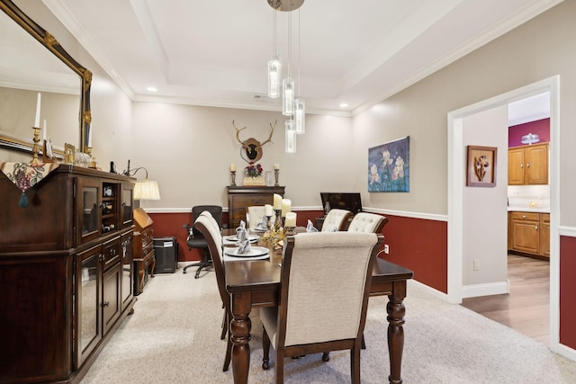 dining space with light carpet, a tray ceiling, recessed lighting, crown molding, and baseboards