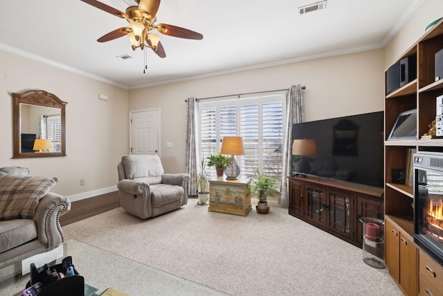 living area featuring baseboards, visible vents, and ornamental molding