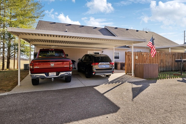 view of parking featuring a carport and fence