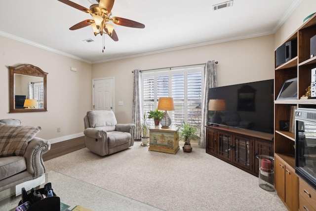 living area featuring visible vents, baseboards, and crown molding