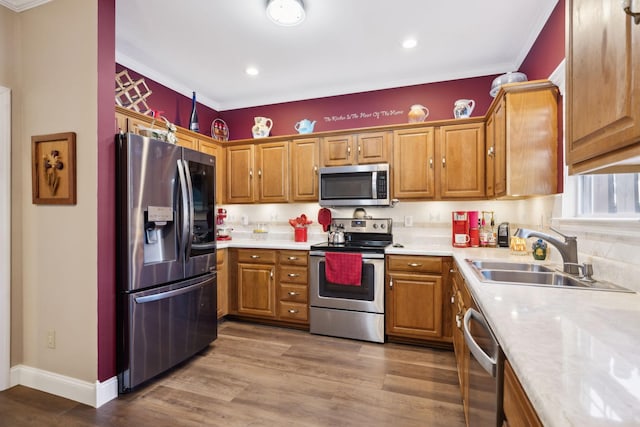 kitchen featuring brown cabinets, stainless steel appliances, light countertops, and a sink