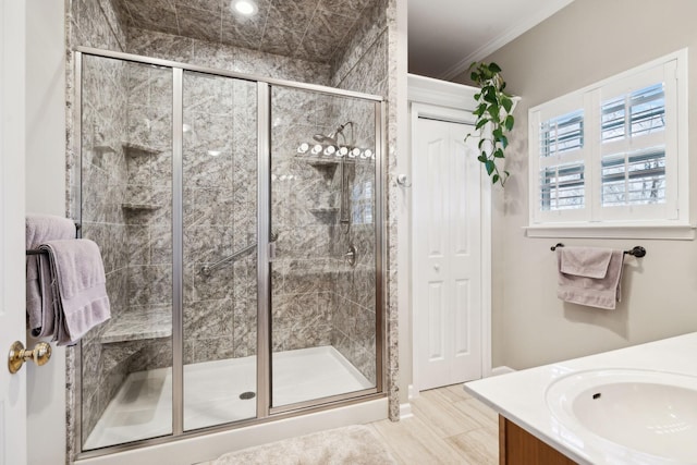 full bath featuring a shower stall, vanity, and ornamental molding