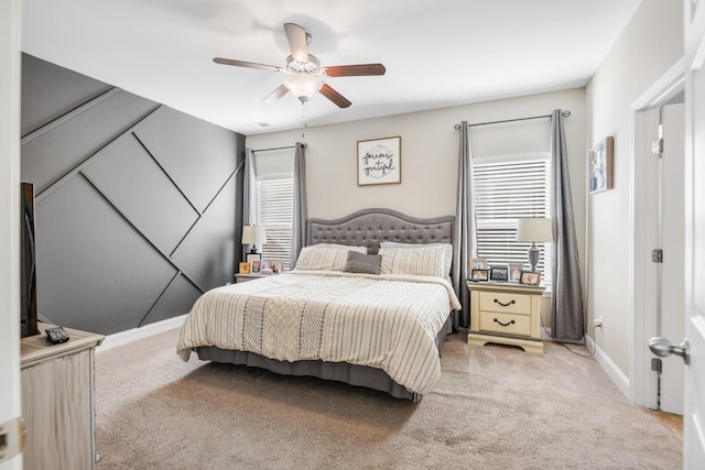 bedroom with multiple windows, light carpet, and a ceiling fan