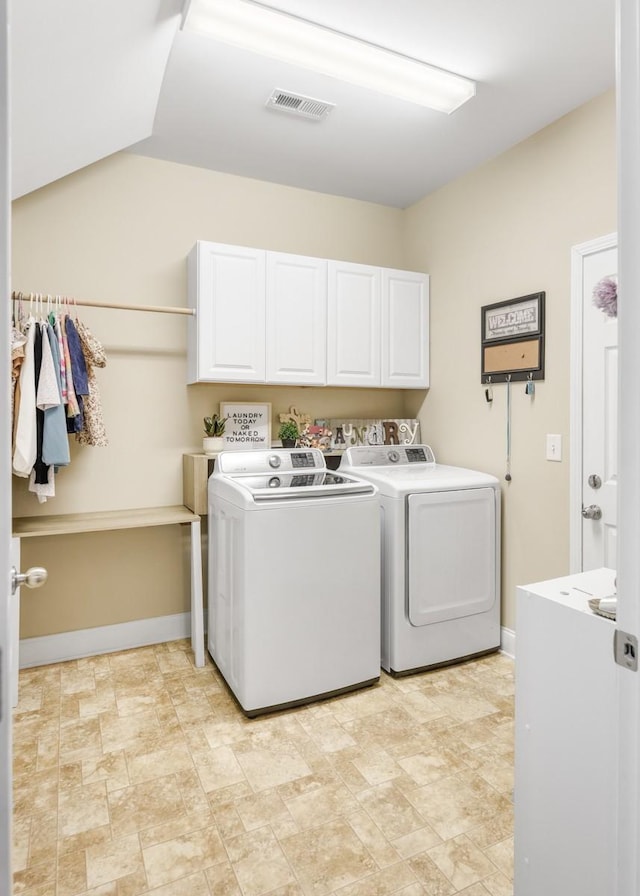 clothes washing area featuring visible vents, cabinet space, separate washer and dryer, and baseboards