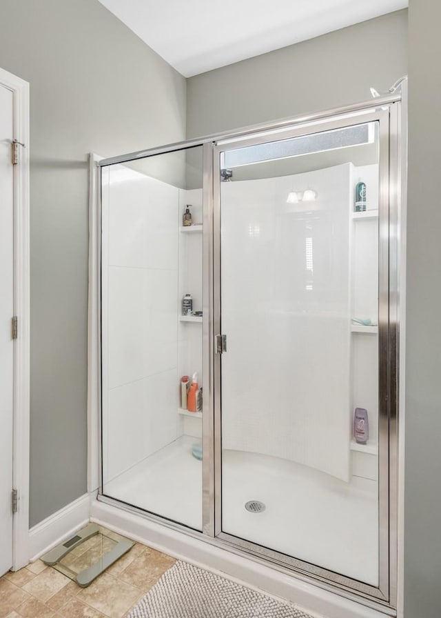 bathroom with a stall shower and baseboards