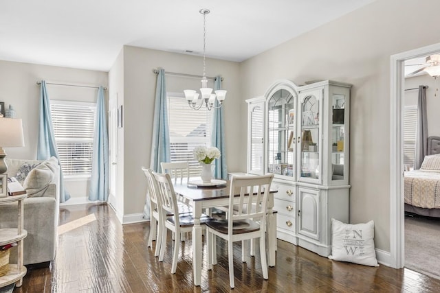 dining space featuring baseboards, an inviting chandelier, and dark wood finished floors