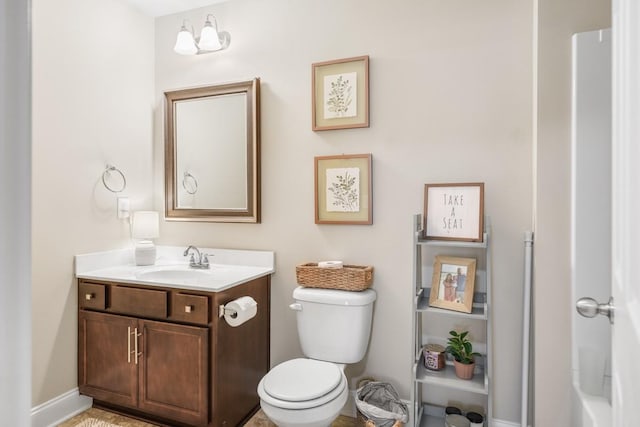 bathroom featuring vanity, toilet, and baseboards