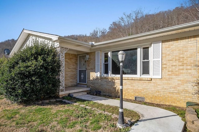 view of front of property with crawl space and brick siding