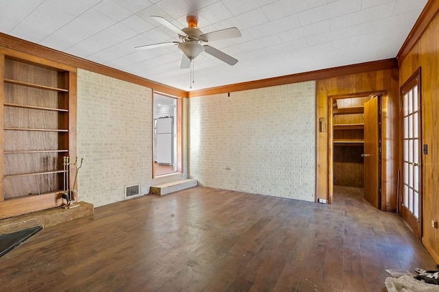 478 S Grundy Quarles Hwy, Gainesboro, TN 38562 - unfurnished living room with visible vents, built in shelves, brick wall, and hardwood / wood-style flooring
