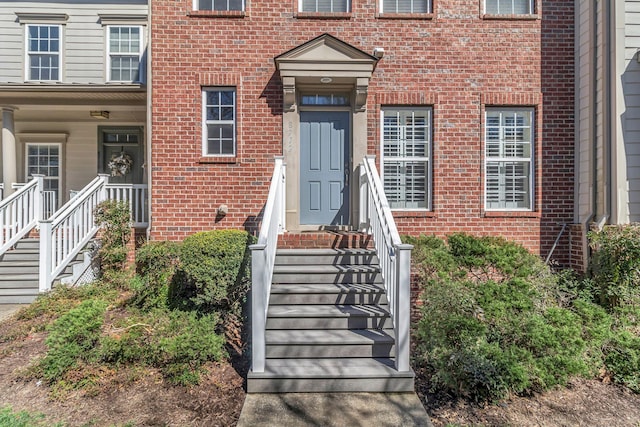 view of exterior entry featuring brick siding