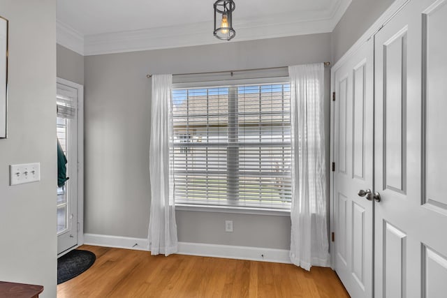 entryway featuring baseboards, wood finished floors, and ornamental molding