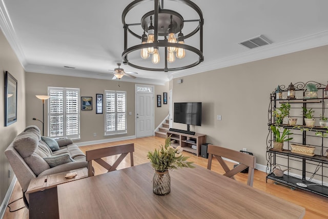 dining area with stairway, baseboards, visible vents, light wood finished floors, and crown molding