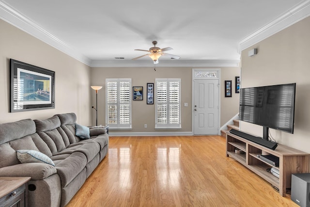 living room featuring visible vents, crown molding, ceiling fan, baseboards, and light wood-style floors