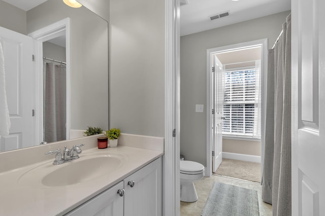 bathroom featuring tile patterned floors, visible vents, toilet, baseboards, and vanity