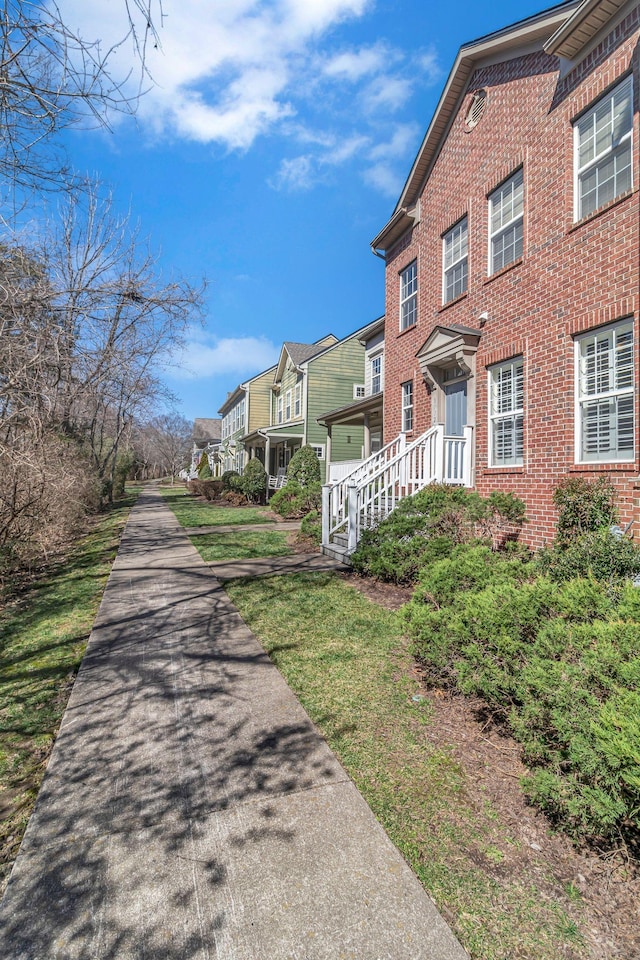 view of side of property featuring brick siding and a residential view