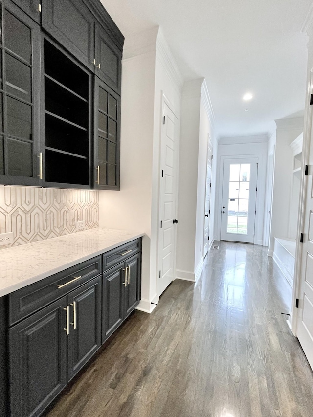 hallway with baseboards, dark wood-style flooring, and ornamental molding