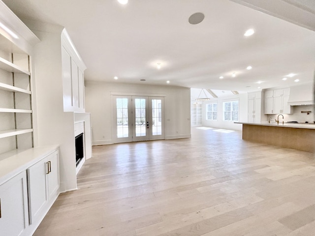 unfurnished living room with light wood finished floors, recessed lighting, and a healthy amount of sunlight