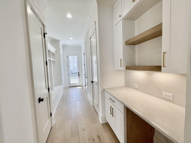 hall featuring recessed lighting, baseboards, and light wood-style floors