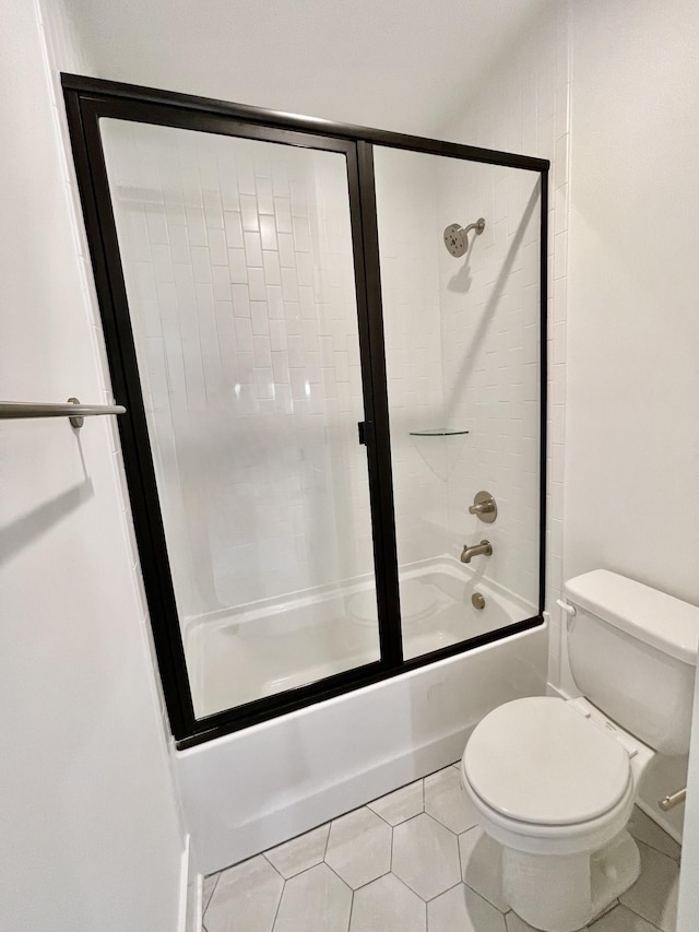 full bathroom featuring enclosed tub / shower combo, toilet, and tile patterned flooring