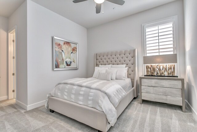 bedroom featuring light colored carpet, baseboards, and ceiling fan