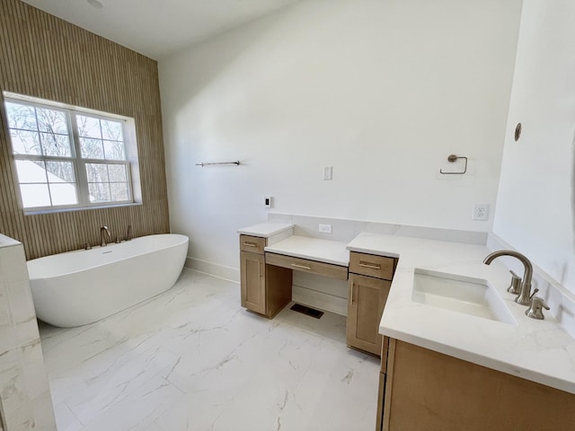 bathroom with visible vents, marble finish floor, baseboards, a freestanding bath, and vanity