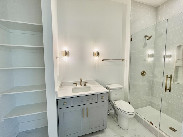 bathroom featuring vanity, a stall shower, a walk in closet, toilet, and marble finish floor