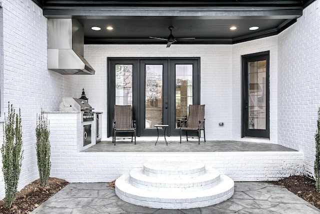 doorway to property with a patio, brick siding, and ceiling fan