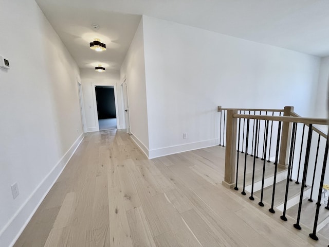 hall featuring baseboards and wood finished floors