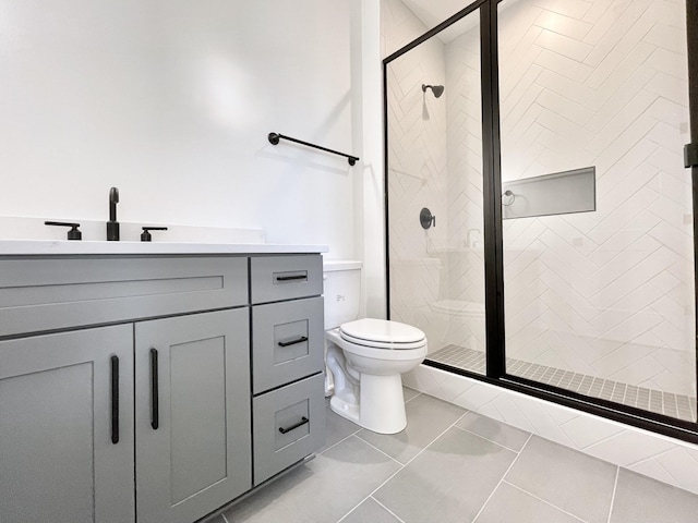 bathroom with vanity, a shower stall, toilet, and tile patterned flooring