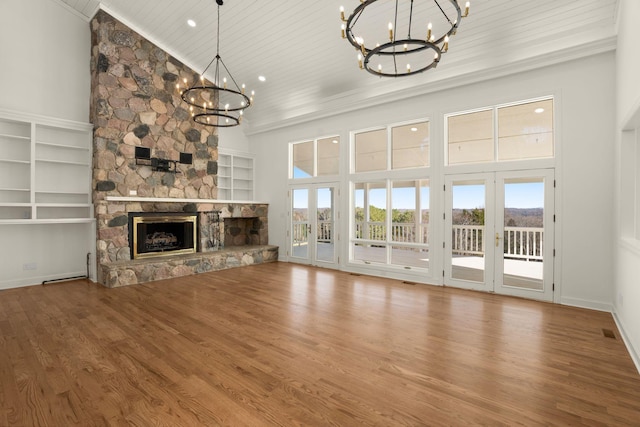 unfurnished living room featuring wood finished floors, high vaulted ceiling, an inviting chandelier, a stone fireplace, and wood ceiling