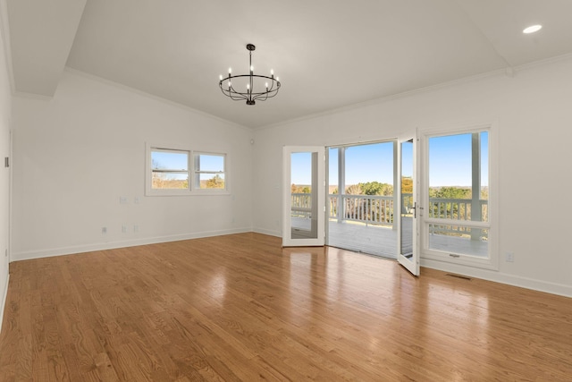 spare room with baseboards, visible vents, ornamental molding, a notable chandelier, and light wood-type flooring