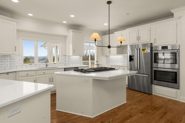 kitchen featuring ornamental molding, a sink, white cabinetry, appliances with stainless steel finishes, and dark wood-style flooring