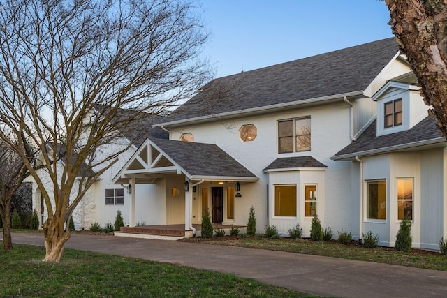 modern farmhouse style home with brick siding, a front lawn, and a shingled roof