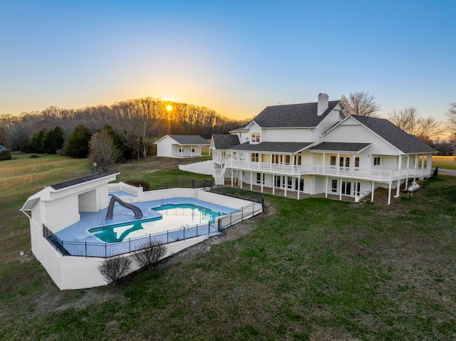 back of house with a lawn, a fenced backyard, a wooden deck, a chimney, and a patio area