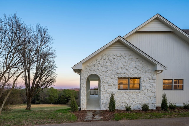 view of front of property with a front yard and stone siding