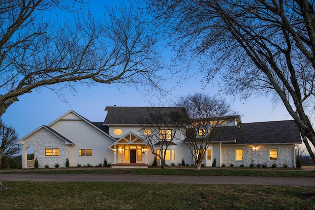 view of front of house featuring stone siding and a front lawn