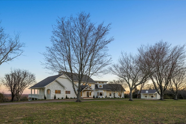 view of front of house with a lawn and stone siding