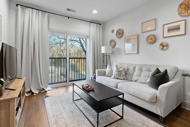 living area with recessed lighting, wood finished floors, and visible vents