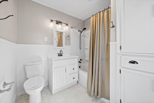 full bath featuring a wainscoted wall, toilet, shower / tub combo with curtain, tile patterned flooring, and vanity