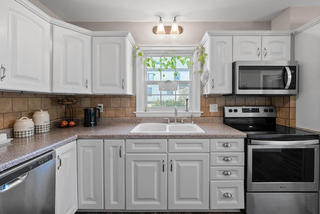 kitchen with a sink, backsplash, white cabinetry, and stainless steel appliances