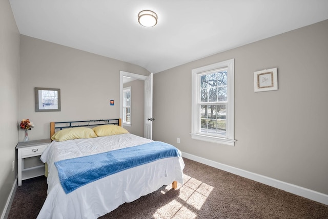 carpeted bedroom with baseboards and vaulted ceiling