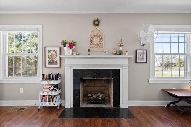 room details with a high end fireplace, visible vents, baseboards, ornamental molding, and wood finished floors