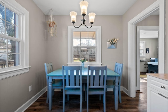 dining space featuring plenty of natural light, baseboards, an inviting chandelier, and dark wood-style flooring