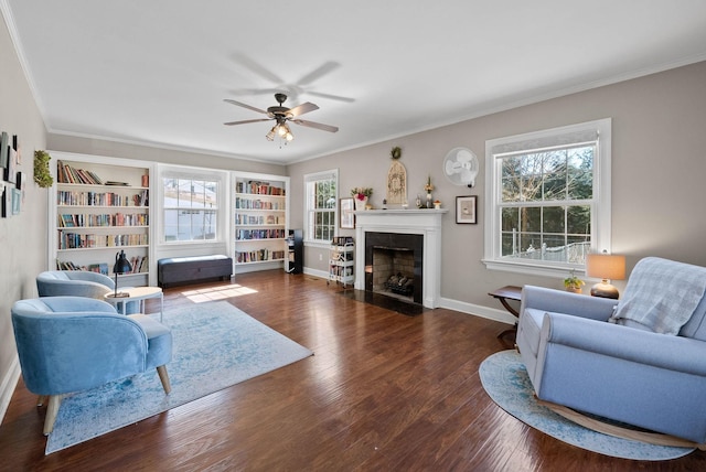 living room with a fireplace with flush hearth, wood finished floors, baseboards, and ornamental molding