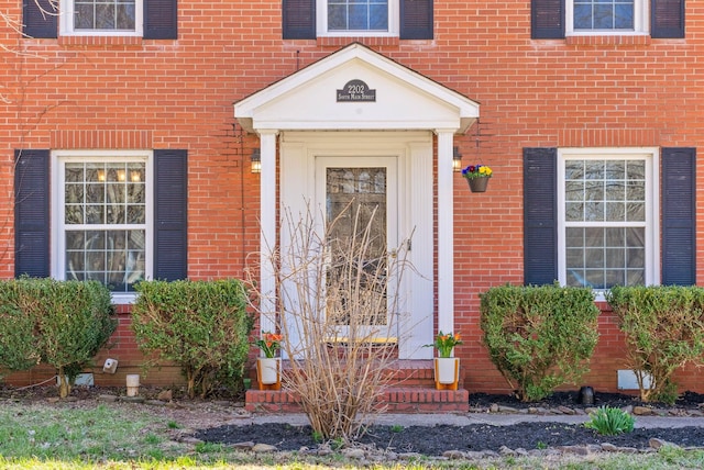 doorway to property featuring brick siding